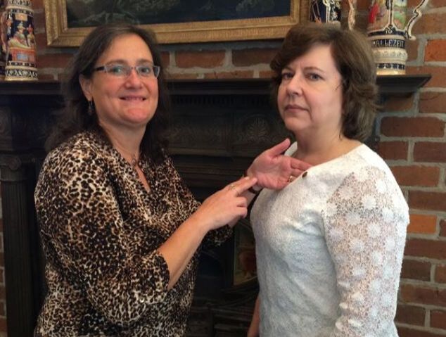 Cathy Butler, right, receives her Accreditation pin from Tracy Sims, APR.