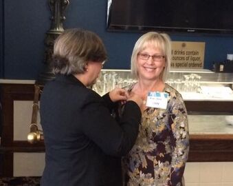 Nancy Randall, right, receives her Accreditation pin from Cathy Butler, APR.